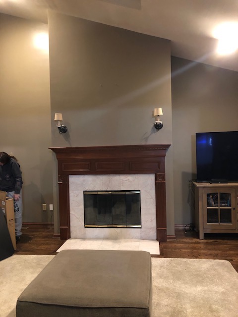 Traditional fireplace with dark wood mantel, white marble surround, and brass-trimmed firebox.